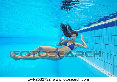 Young woman wearing a bikini while swimming under water in a open-air pool. View Large Photo Image Stock Image - Young woman wearing a bikini while swimming under water in a open-air pool.. Fotosearch