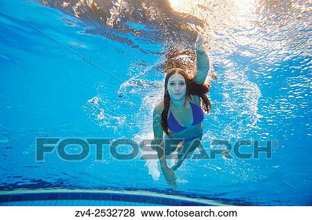 Young woman wearing a bikini while swimming under water in a open-air pool. View Large Photo Image Stock Photo - Young woman wearing a bikini while swimming under water in a open-air pool.. Fotosearch