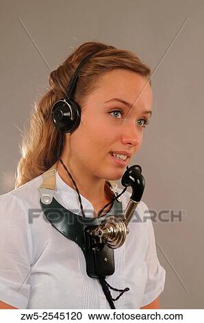 Stock Image - Young woman with an old headset telephone in Sweden.. Fotosearch