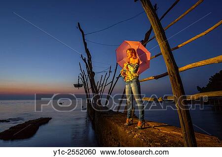 Stock Image - Young woman with umbrela.. Fotosearch