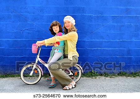7 years old girl on bicycle and her mother front a blue wall in Caños de Meca, Cádiz, Andalucia, Spain View Large Photo Image Stock Image - 7 years old girl on bicycle and her mother front a blue wall in Caños de Meca, Cádiz, Andalucia, Spain. Fotosearch