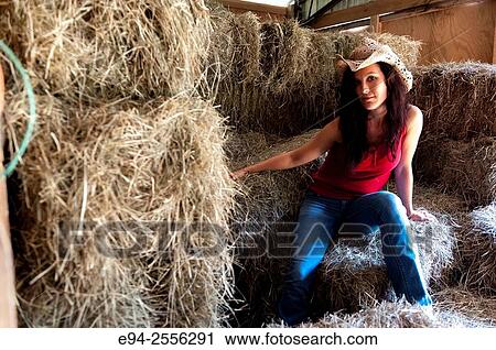 A 38 year old brunette woman sitting on a pile of hay bales. View Large Photo Image Stock Image - A 38 year old brunette woman sitting on a pile of hay bales.. Fotosearch