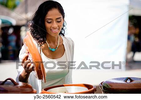 A hispanic woman is checking a pot at a street market in Puerto Vallarta, Mexico. View Large Photo Image Stock Image - A hispanic woman is checking a pot at a street market in Puerto Vallarta, Mexico.. Fotosearch