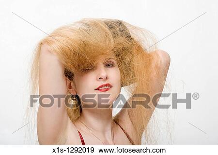 A lady with long blond hair and fair skin uses both hands to hold her hair above her head. View Large Photo Image Stock Photo - A lady with long blond hair and fair skin uses both hands to hold her hair above her head.. Fotosearch