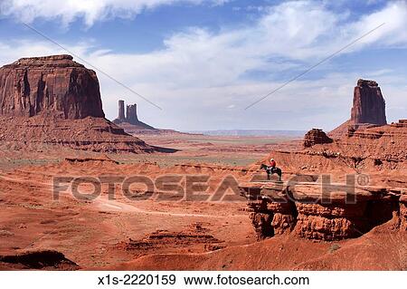 A lone cowboy sitting on a horse looks out from a mesa on to the vast landscape of Monument Valley. View Large Photo Image Stock Photo - A lone cowboy sitting on a horse looks out from a mesa on to the vast landscape of Monument Valley.. Fotosearch