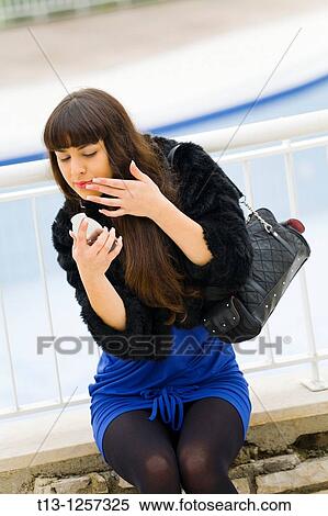 Adjusting lips make-up young lady View Large Photo Image Stock Photography - Adjusting lips make-up young lady. Fotosearch