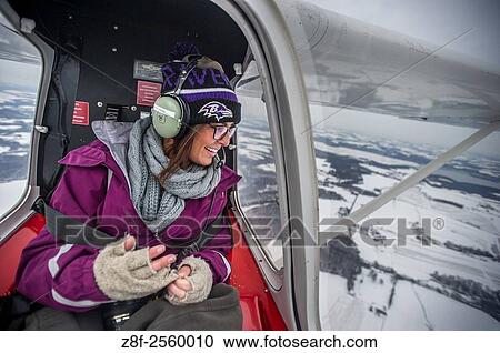 Aerial of young woman looking out of a window in the back of a small airplane flying over Lancaster county, Pennsylvania. USA View Large Photo Image Stock Image - Aerial of young woman looking out of a window in the back of a small airplane flying over Lancaster county, Pennsylvania. USA. Fotosearch