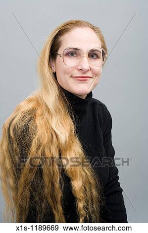 An attractive American woman with beautiful long, flowing blond hair looks like a librarian View Large Photo Image Stock Photo - An attractive American woman with beautiful long, flowing blond hair looks like a librarian. Fotosearch