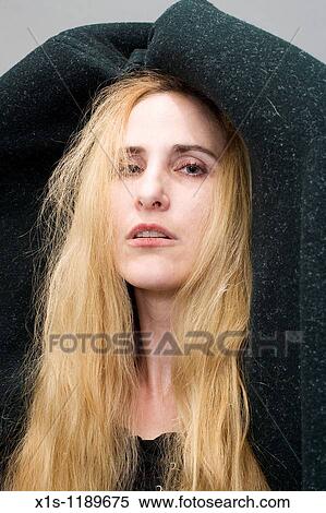 Stock Photography - An attractive American woman with beautiful long, flowing blond hair from within a cape. Fotosearch