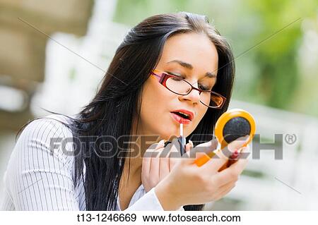 Applying lips make-up on the street young woman View Large Photo Image Stock Photo - Applying lips make-up on the street young woman. Fotosearch