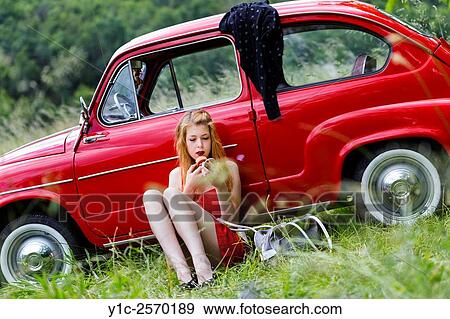 Stock Photo - Applying make-up foundation young woman and Fiat 750. Fotosearch