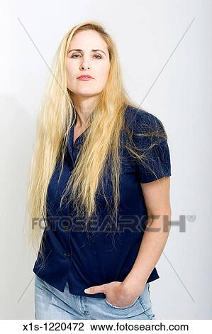 Attractive blond American woman wearing blue jeans and a dark shirt has one hand in a pocket and looks at the camera. View Large Photo Image Stock Image - Attractive blond American woman wearing blue jeans and a dark shirt has one hand in a pocket and looks at the camera.. Fotosearch