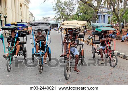 Bicycle taxis await passengers in Santa Clara, Cuba View Large Photo Image Stock Image - Bicycle taxis await passengers in Santa Clara, Cuba. Fotosearch