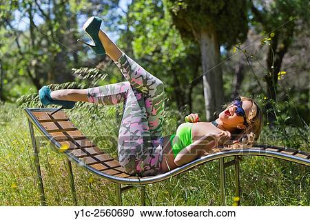 Stock Image - Cheerful young woman on deckchair. Fotosearch