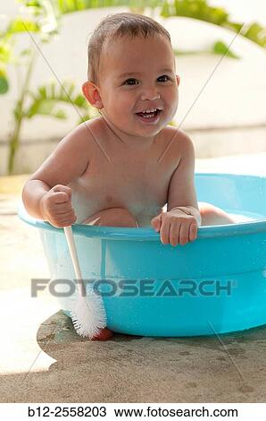 Child playing in a basin of water. View Large Photo Image Stock Image - Child playing in a basin of water.. Fotosearch