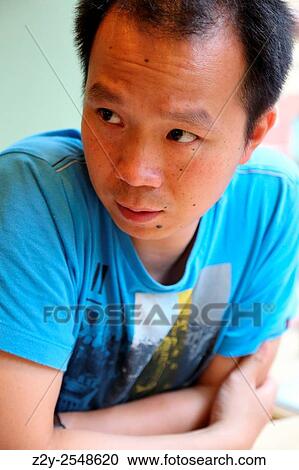 Stock Image - Chinese young man looking confused.. Fotosearch