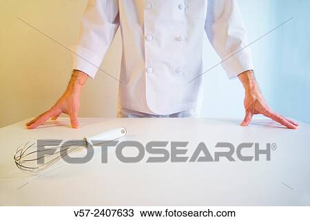 Cook behind a white table, hands on the table and whisk in the forefront. View Large Photo Image Stock Image - Cook behind a white table, hands on the table and whisk in the forefront.. Fotosearch