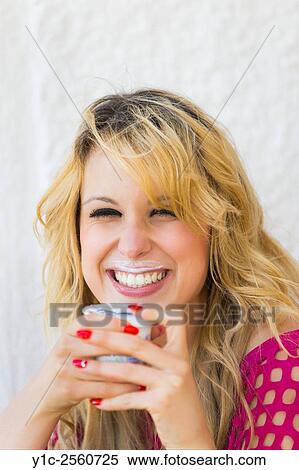 Stock Photography - Eating yogurt messy lips smiling woman portrait. Fotosearch