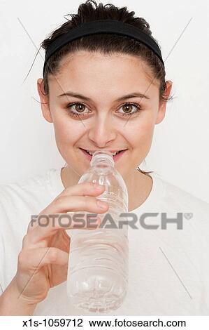 Fit young woman taking a drink of water from a transparent water bottle View Large Photo Image Stock Image - Fit young woman taking a drink of water from a transparent water bottle. Fotosearch