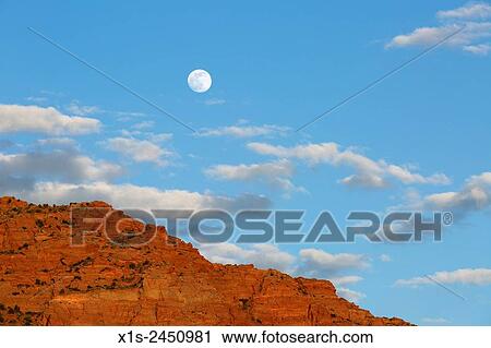Stock Image - Full moon rises over a wilderness landscape in the American Southwest.. Fotosearch