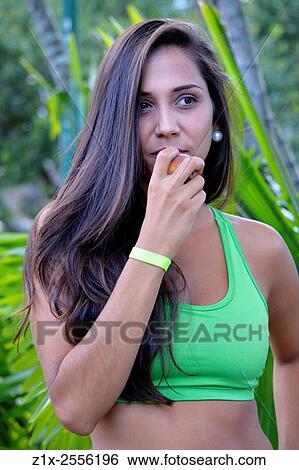 Stock Photograph - Girl eating fruit. Venezuela.. Fotosearch