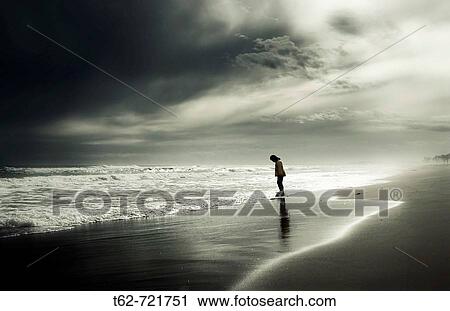 Joven paseando solo por la orilla del mar en invierno. View Large Photo Image Stock Image - Joven paseando solo por la orilla del mar en invierno.. Fotosearch