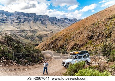 Land Rover Defender parked on a dirt road and a man standing with a camera in Sani pass between South Africa and Lesotho. View Large Photo Image Stock Image - Land Rover Defender parked on a dirt road and a man standing with a camera in Sani pass between South Africa and Lesotho.. Fotosearch