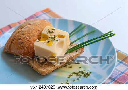 Stock Photo - Maasdam cheese on bread with chives and olive oil.. Fotosearch