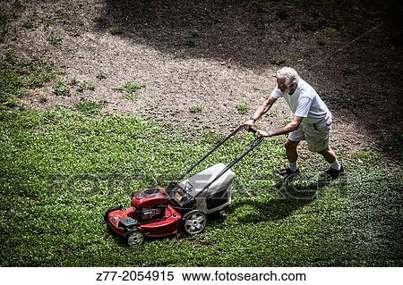 Stock Photography - Man mowing the lawn.. Fotosearch
