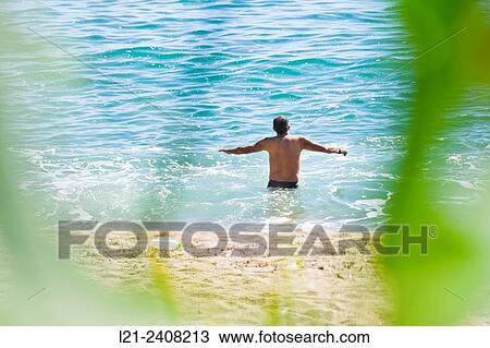 Man on beach, bather at sea. Tossa de Mar, Catalonia, Spain. View Large Photo Image Stock Image - Man on beach, bather at sea. Tossa de Mar, Catalonia, Spain.. Fotosearch