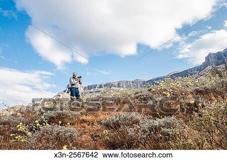 Man photographing the landscape in Sani Pass, between South Africa and Lesotho. View Large Photo Image Stock Image - Man photographing the landscape in Sani Pass, between South Africa and Lesotho.. Fotosearch