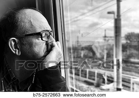 Middle-aged man, with glasses, looking through the window of a train. Italy, Europe View Large Photo Image Stock Image - Middle-aged man, with glasses, looking through the window of a train. Italy, Europe. Fotosearch