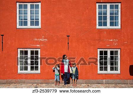 Mother and two child on a red wall. Kastellet, Copenhagen. Denmark. View Large Photo Image Stock Photo - Mother and two child on a red wall. Kastellet, Copenhagen. Denmark.. Fotosearch