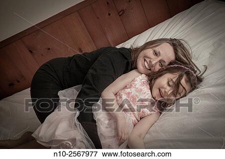Stock Photo - Mother playing with her six year old daughter.. Fotosearch