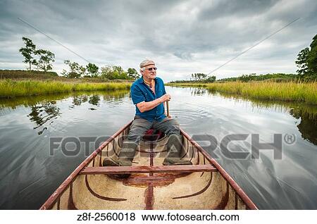 Native American man in a canoe in the river at Bending Waters Park, Marion Station, Maryland, USA. View Large Photo Image Stock Photo - Native American man in a canoe in the river at Bending Waters Park, Marion Station, Maryland, USA.. Fotosearch