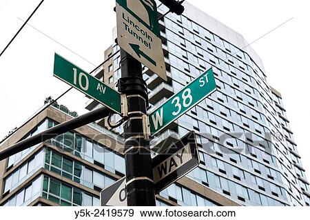 New York, USA. Lamppost and street signs in front of a skyscraper on the corner of 10th Avenue & West 28th Street, Manhattan. View Large Photo Image Stock Photo - New York, USA. Lamppost and street signs in front of a skyscraper on the corner of 10th Avenue & West 28th Street, Manhattan.. Fotosearch