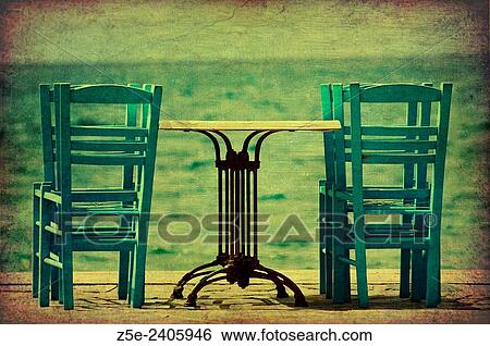 Stock Photograph - One table and six chairs by the sea on Pelion Peninsula, Thessaly, Greece. Fotosearch