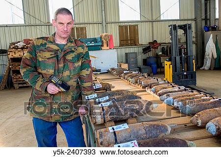 Poelkapelle, Belgium. Army Battalion for Demolition of Explosives. Army chief corporal working on the identification and classification of recovered live World War 1 shells and munition, prior to demolition. View Large Photo Image Stock Image - Poelkapelle, Belgium. Army Battalion for Demolition of Explosives. Army chief corporal working on the identification and classification of recovered live World War 1 shells and munition, prior to demolition.. Fotosearch