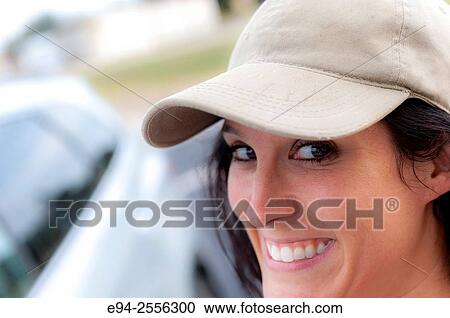 Portrait of a 38 year old brunette woman outdoors, wearing a ball cap. View Large Photo Image Stock Image - Portrait of a 38 year old brunette woman outdoors, wearing a ball cap.. Fotosearch