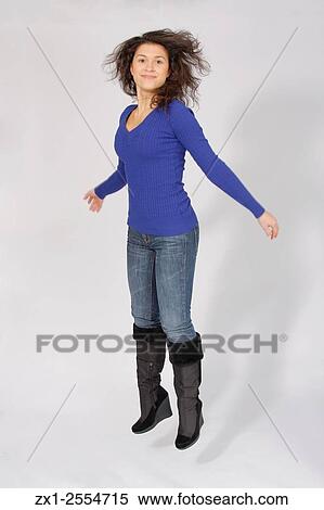Portrait of a women in a blue long sleeve v-neck sweater in jeans on a white backdrop. View Large Photo Image Stock Photography - Portrait of a women in a blue long sleeve v-neck sweater in jeans on a white backdrop.. Fotosearch