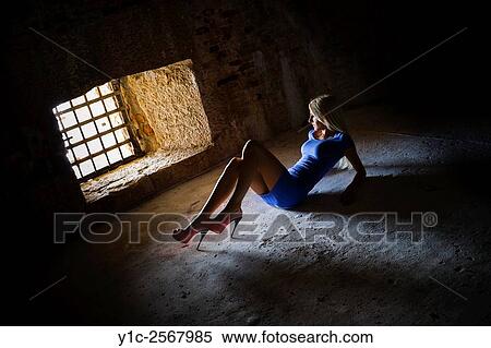 Stock Photography - Pretty and slender young woman posing against light. Fotosearch