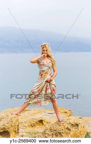 Stock Image - Pulling dress seductively young woman.. Fotosearch