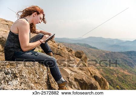 Red-headed girl writing in a journal on top of a boulder at Mlilwane Wildlife Sanctuary in Swaziland, Africa. View Large Photo Image Stock Image - Red-headed girl writing in a journal on top of a boulder at Mlilwane Wildlife Sanctuary in Swaziland, Africa.. Fotosearch