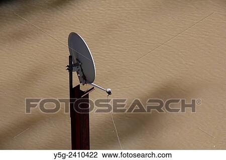 Satellite dish on top of a pole above brown river water View Large Photo Image Stock Image - Satellite dish on top of a pole above brown river water. Fotosearch