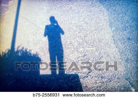 Stock Image - Self-Portrait. Selfie. Shadow of the photographer reflected in the sea. Port Mahon, Menorca, Mediterranean sea, Balearic Islands, Spain, Europe. Fotosearch