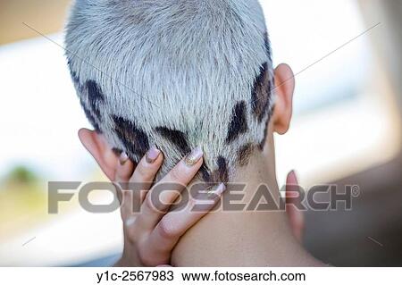 Stock Image - Short-haired young woman rear-view hairdo with Black patches. Fotosearch