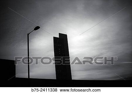 Stock Photo - Silhouette of skyscrapers Broadgate Tower building with a lamp post in foreground at sunset in Shoreditch High Street, East London, England, UK, Europe.. Fotosearch