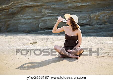 Stock Photo - Stock Photo - Drinking water from plastic bottle on beach teenager. Fotosearch