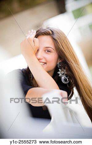 Stock Image - Stock Photo - Peeking on one eye laughing teen girl. Fotosearch