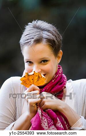 Stock Photo - Shy teenager girl behind Autumn leaf View Large Photo Image Stock Image - Stock Photo - Shy teenager girl behind Autumn leaf. Fotosearch
